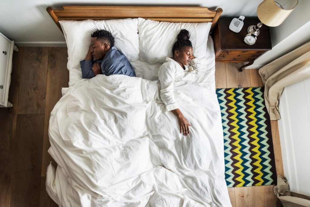 Sleep Talking: What Is Somniloquy? A couple in bed facing away from each other