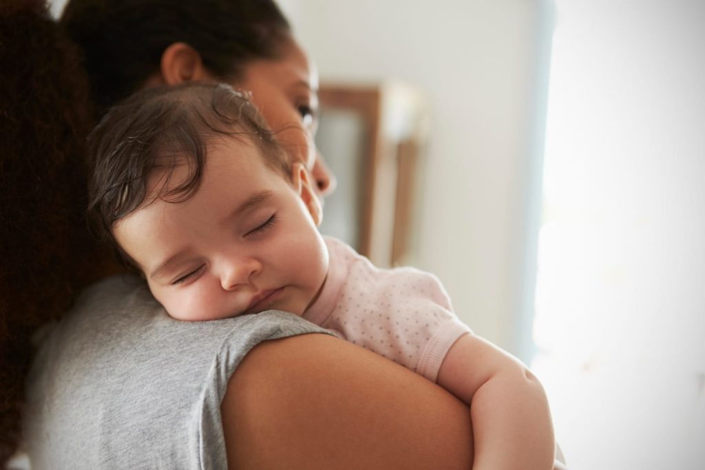 Sleep Deprivation and Postpartum Depression woman holding sleeping baby