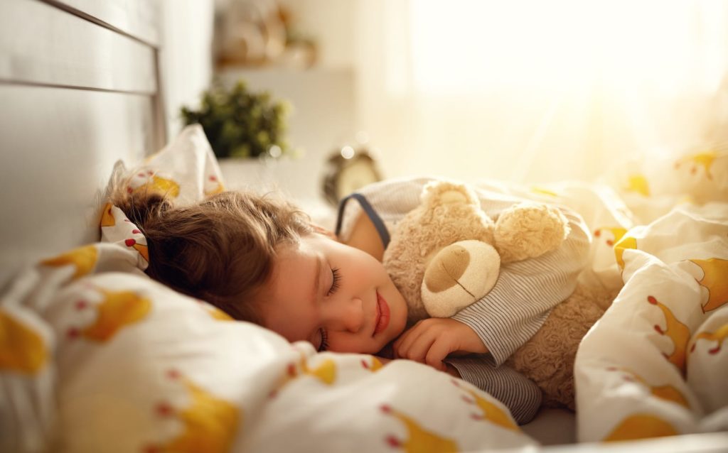 Melatonin for Kids: A Guide for Parents and Caregivers Sleeping child holding teddy bear