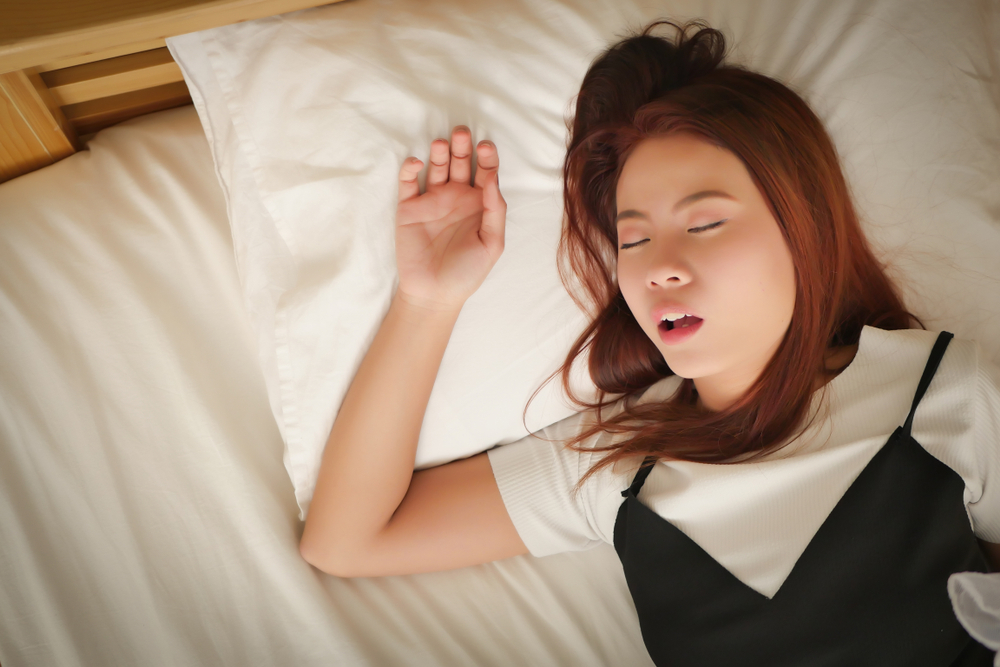What Causes Snoring In Women? Tired woman snoring in bed